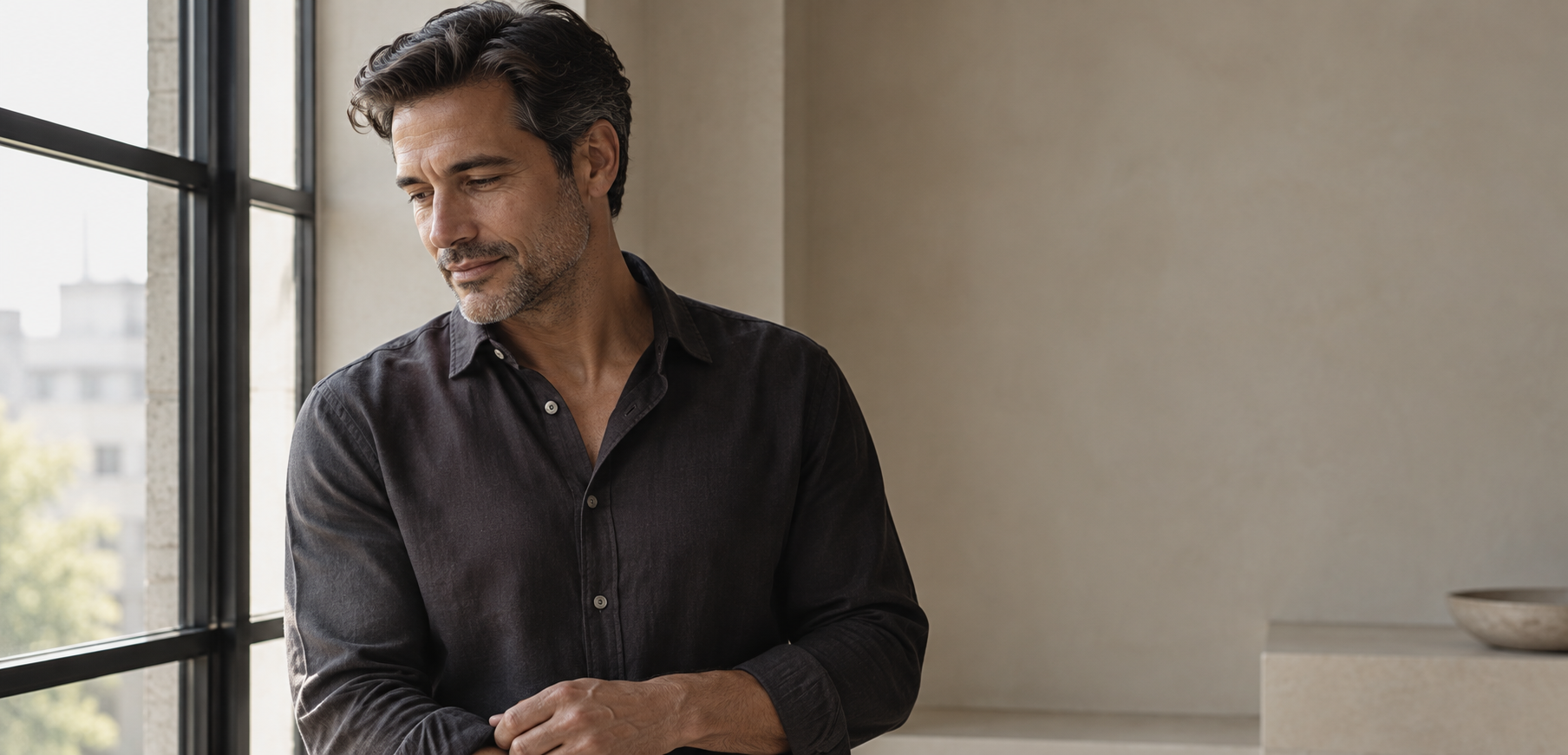 Editorial portrait of a man by a window in soft natural light
